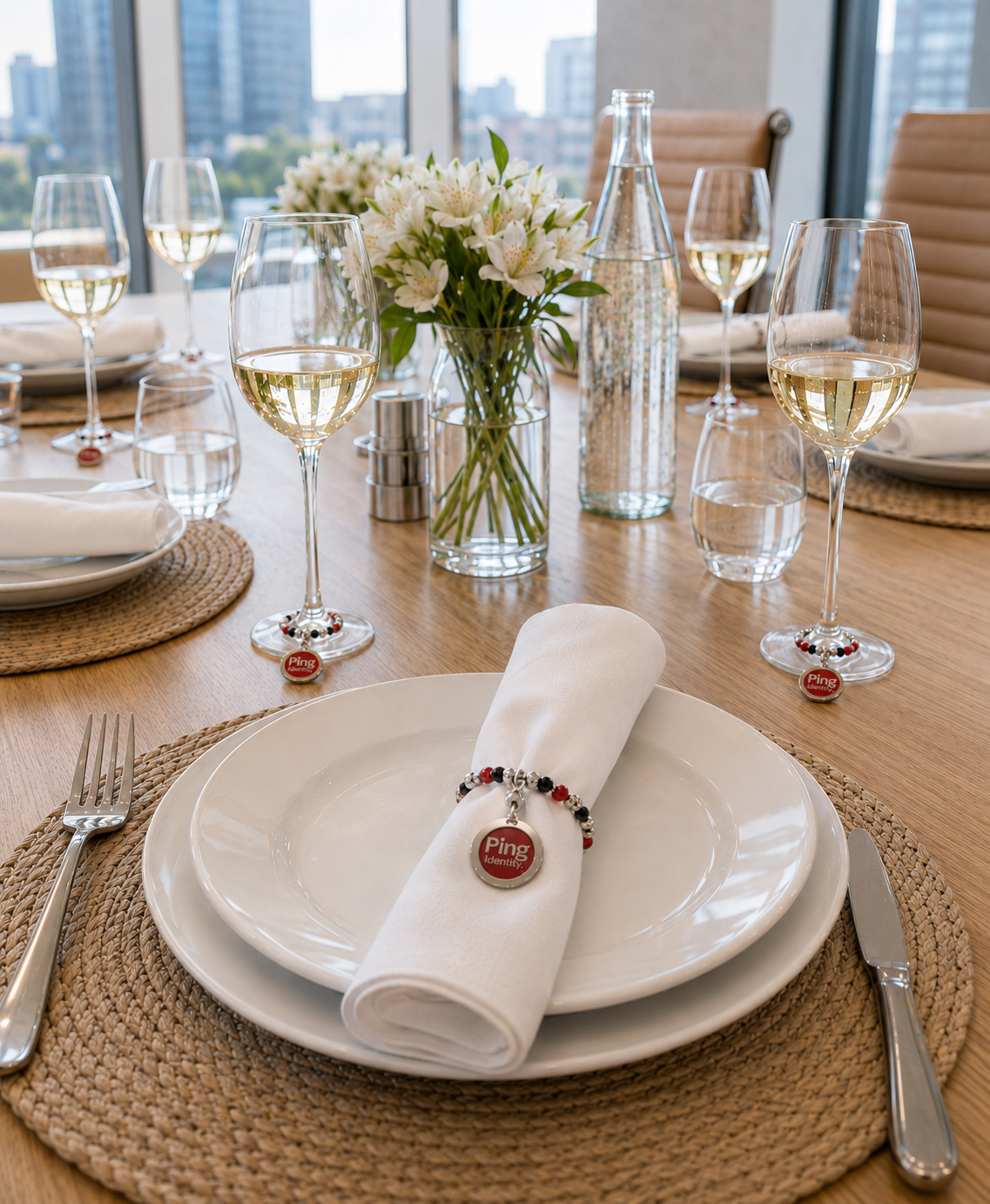 Custom company logo napkin ring with red, black and silver beads on a white napkin at a corporate event table.