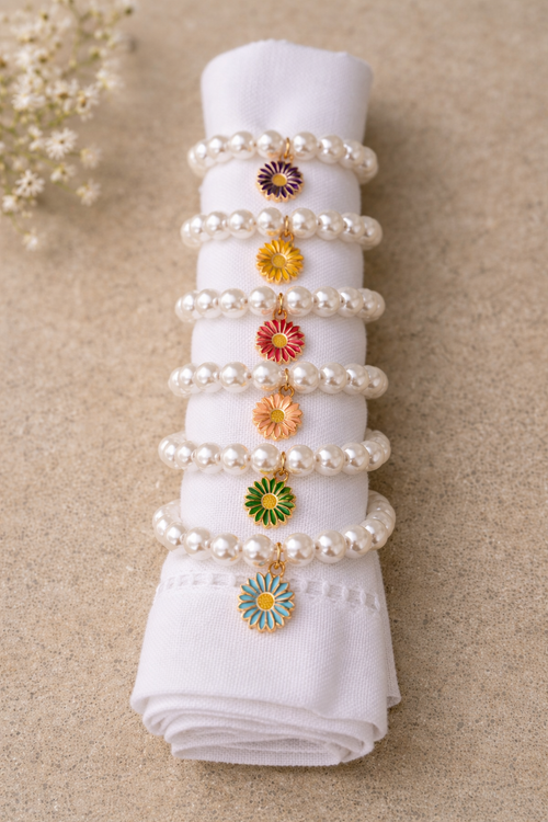 set of 6 napkin rings with colorful flowers held between pearly beads on white linen napkins for perfect table decor