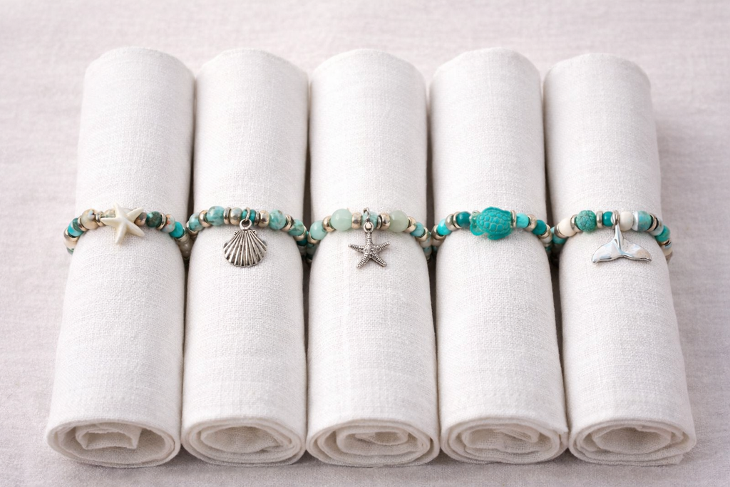 seet of6 sea themed turuoise beaded napkin rings on white napkins. Set of 6