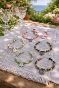 flower napkin rings with colorful beads and flower charms set of 6 on neutral tablecloth with crystal wine glasses