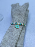 Turquoise and gold beaded napkin rings with star charms on elegant neutral table setting by the pool, Mediterranean coastal table decor, set of 6 by My Charmed Life